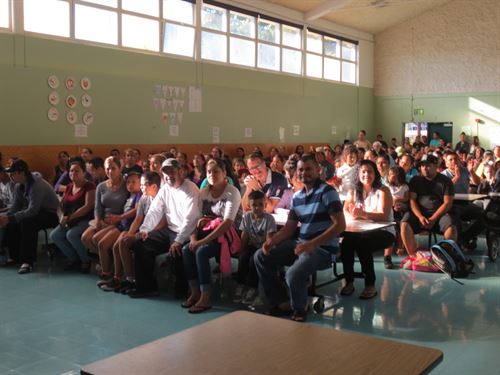 Parents attending a parent meeting with their children.