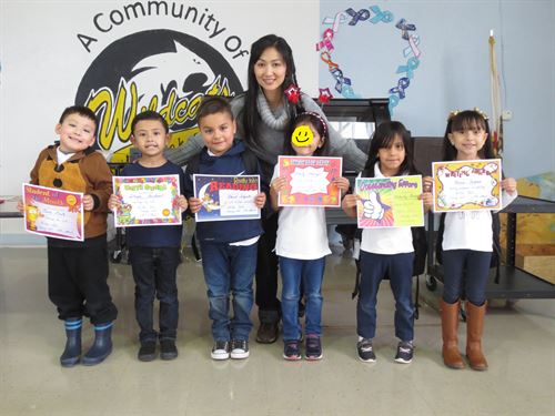 Kinder students standing on stage with their monthly awards