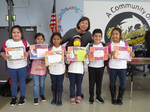 Kinder students standing on stage with their awards