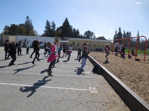 Photo of teacher and students jumping during PE